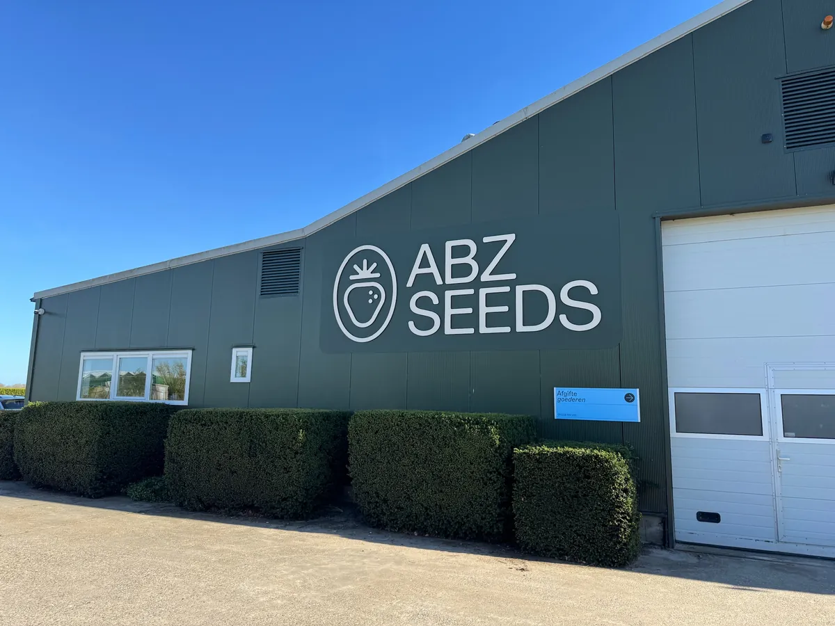 Groene loods met logo en letters ABZ SEEDS en een blauw bord