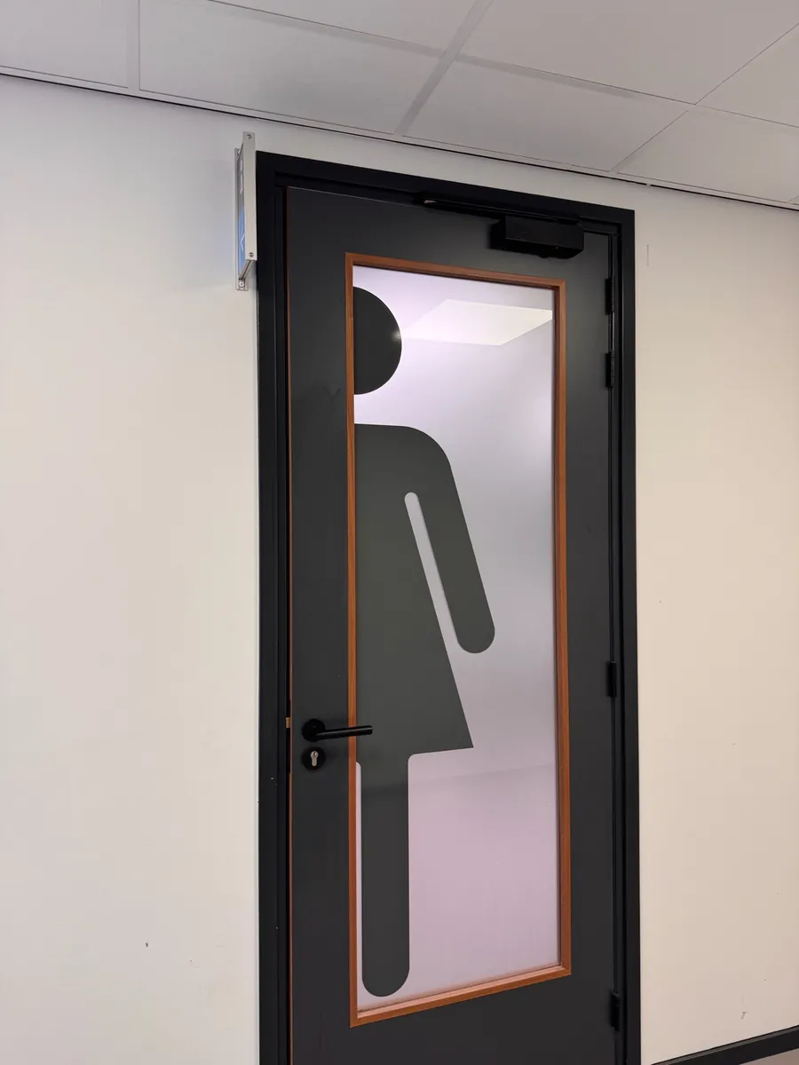 Donkere deur met een groot pictogram in folie op het glas
