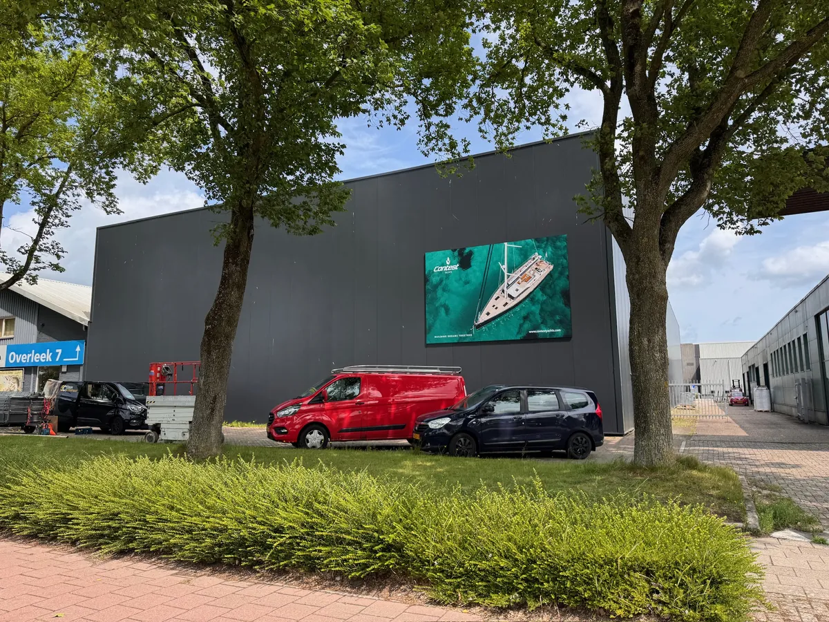 Donkere hal met het gevelbeeld van een jacht, bomen ervoor