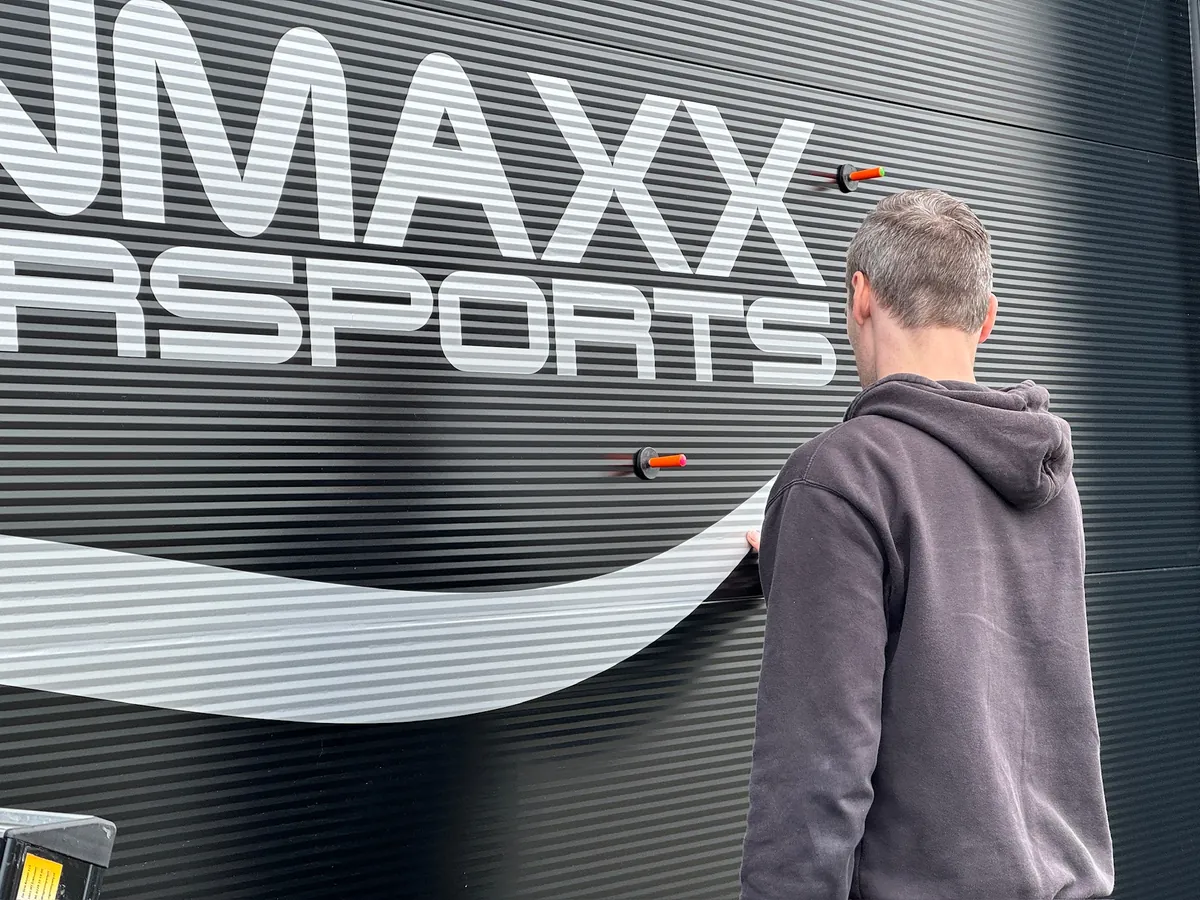 Monteur brengt de witte golf onder FUNMAXX aan op de gevel