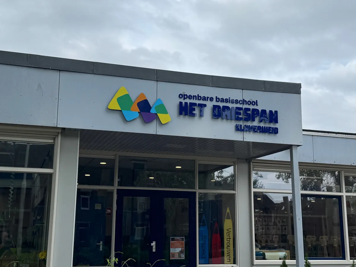 Kleurrijk logo en blauwe letters openbare basisschool Het Driespan boven de entree