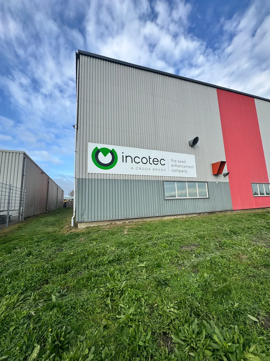 Hal met het incotec-bord op de grijze gevel naast een rode strook
