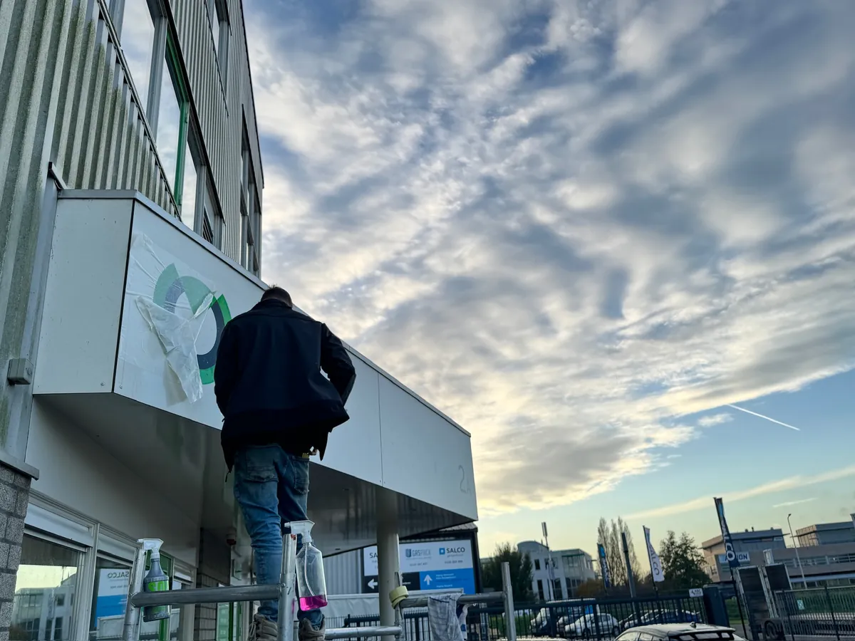 Monteur op een trap bij de luifel met het incotec-logo