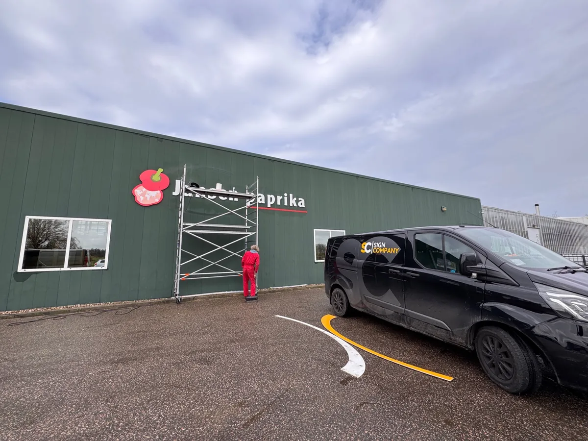 Steiger voor de groene loods met Jansen paprika en de bus ervoor