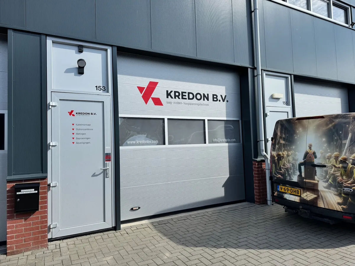 Bedrijfspand met het Kredon-logo boven de roldeur en belettering op de deur