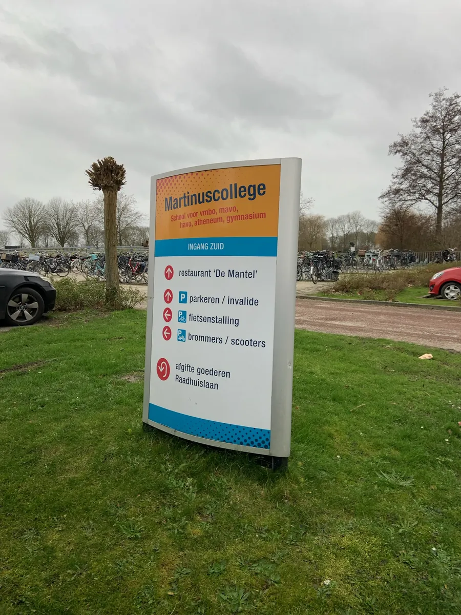 Kleurige zuil van het Martinuscollege met routes naar restaurant en parkeren