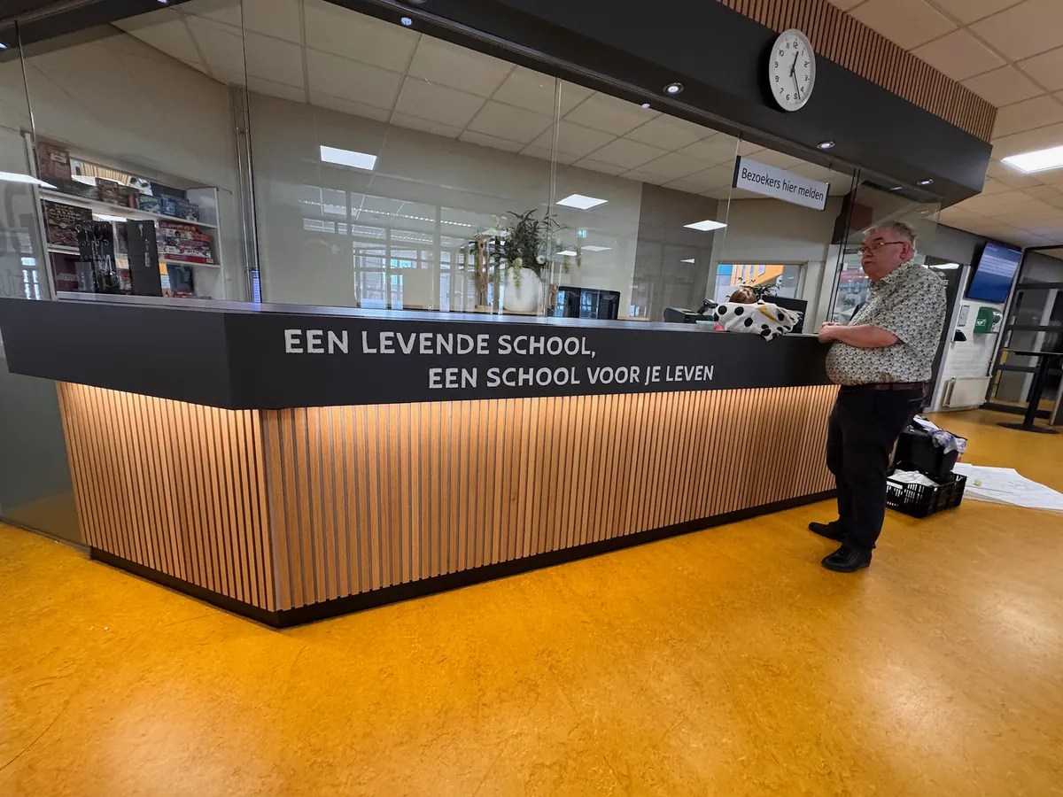 Ontvangstbalie met de tekst Een levende school, een school voor je leven