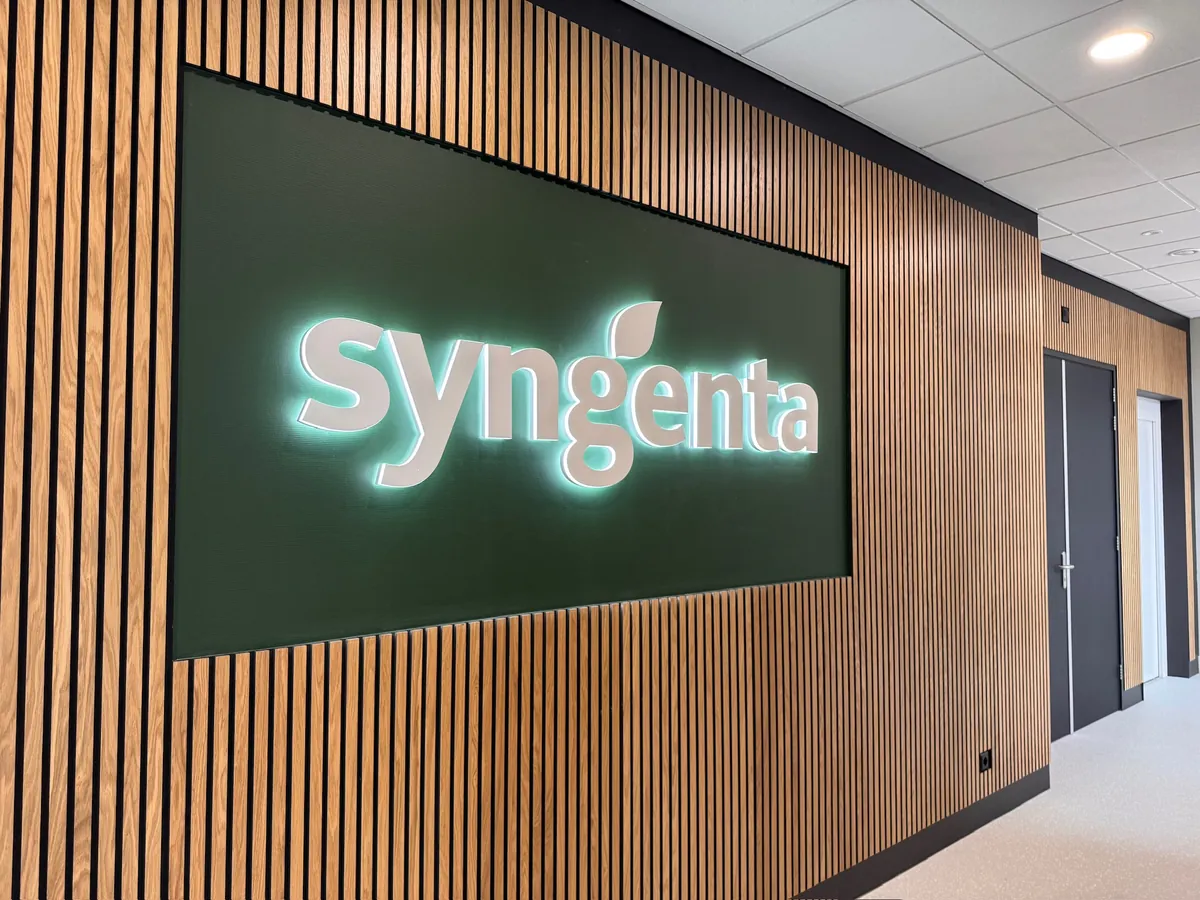Verlicht syngenta-logo op een groen paneel in een houten lamellenwand