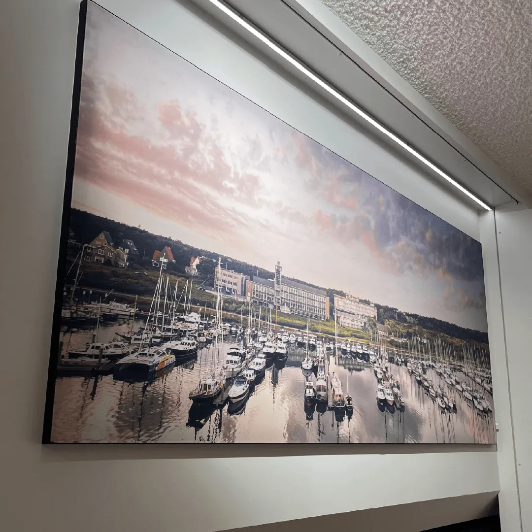 Wanddoek van een jachthaven met roze avondlucht, uitgelicht met een lichtlijn aan het plafond