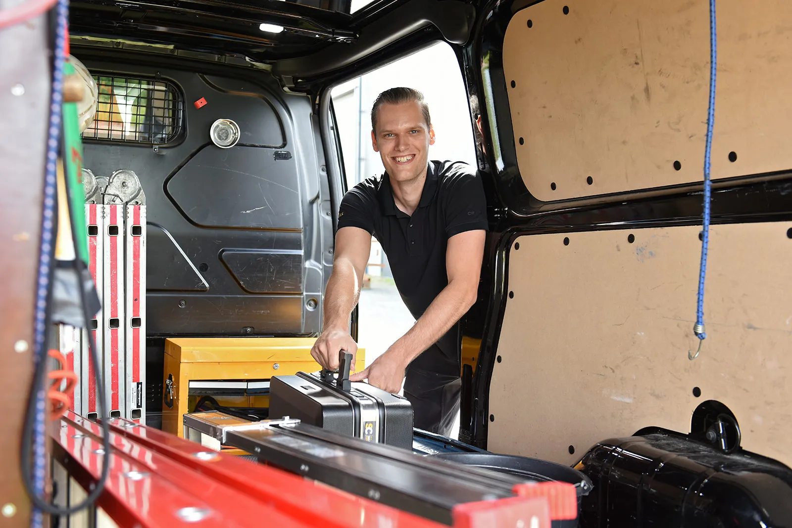 Daan laadt gereedschap in de bedrijfsbus voor een montage