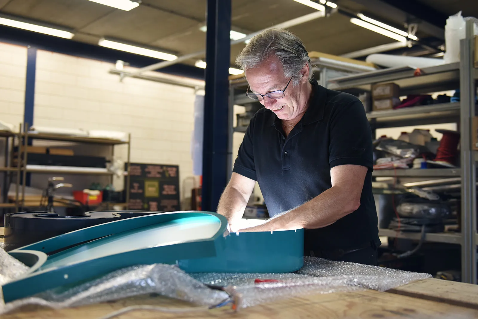 Jos Bootsma werkt aan een lichtbak in de werkplaats van Sign Company in Enkhuizen